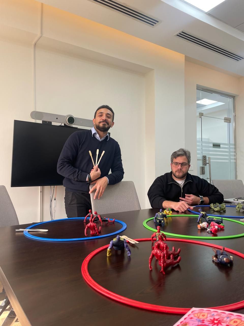 A playful team activity with action figures and colored rings